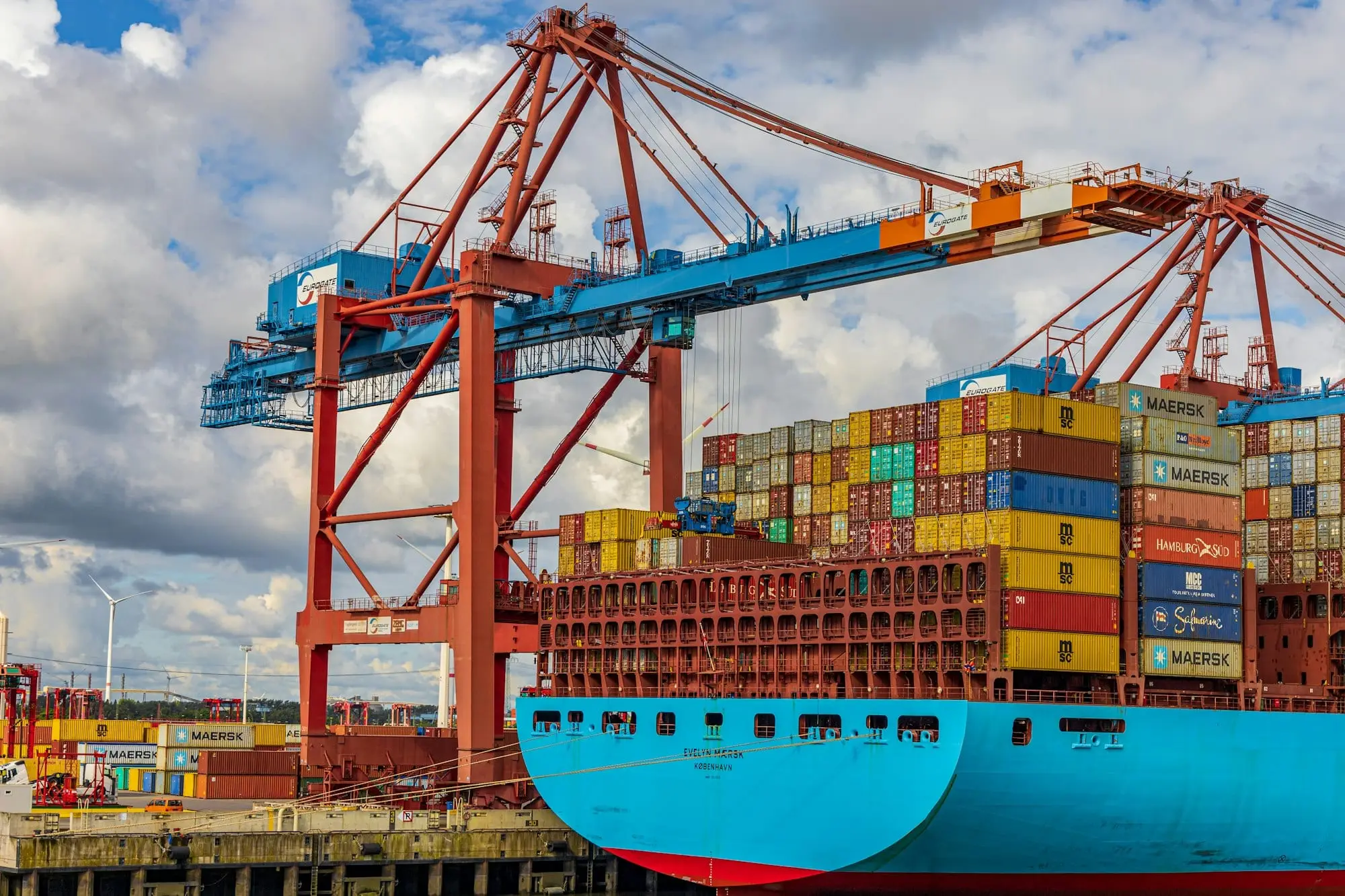 A container ship being loaded under port cranes